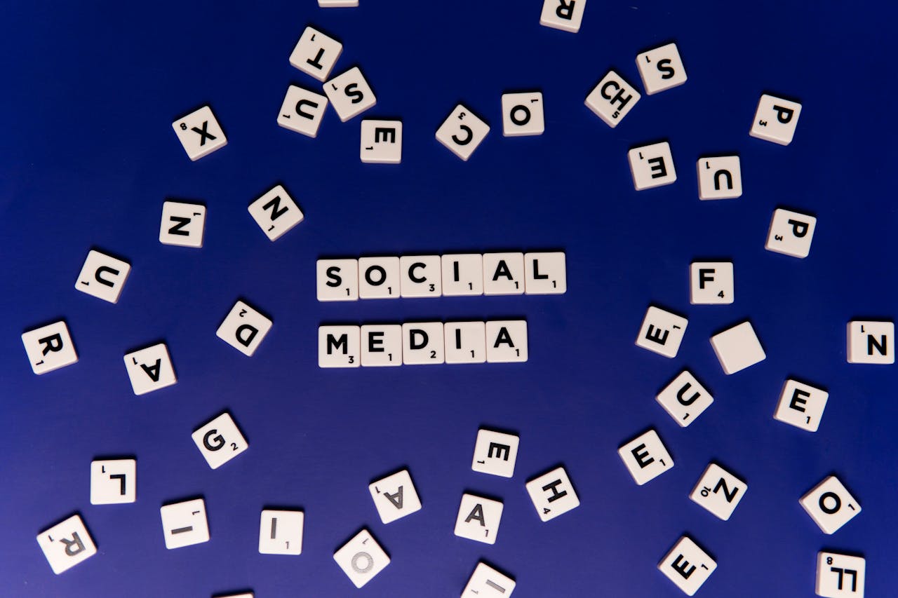 about-us Scrabble tiles spelling 'Social Media' on a blue background, ideal for digital marketing themes.