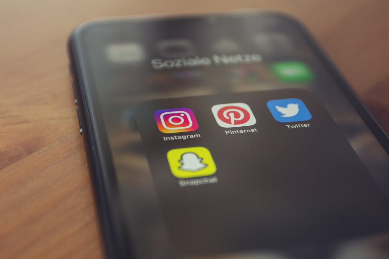 services-03 Smartphone displaying popular social media apps like Instagram, Pinterest, Twitter, and Snapchat.